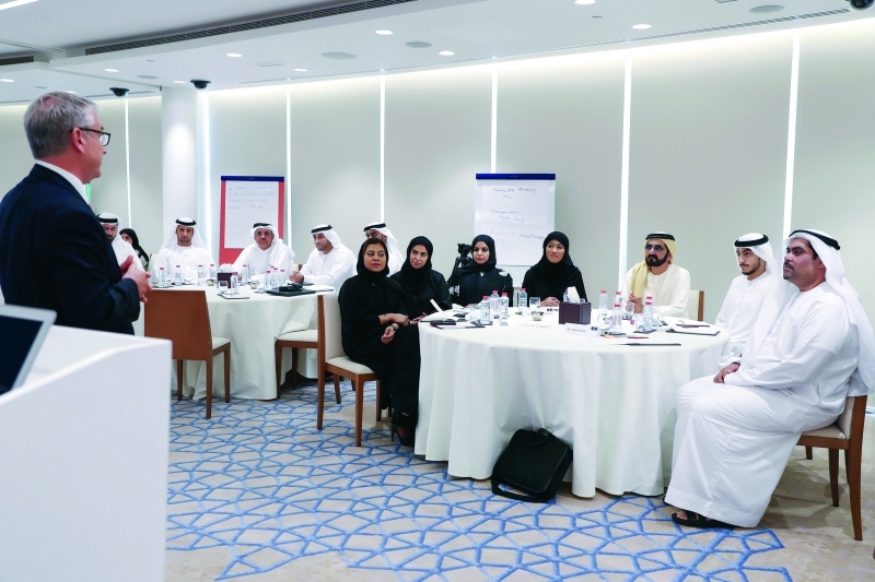 "■ نائب رئيس الدولة مستمعاً إلى المحاضر بحضور محمد القرقاوي وشباب وشابات البرنامج التدريبي"