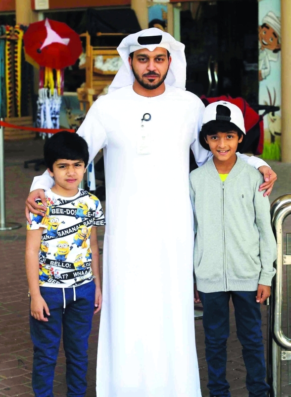 "حمد العامري مع طفلين زائرين للحديقة"