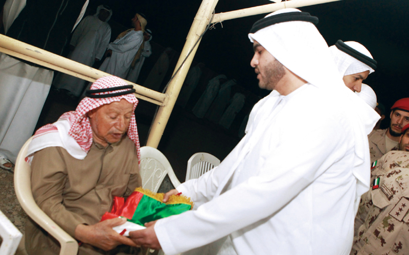 "والد الشهيد يتلقى علم الإمارات"