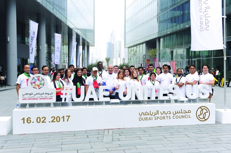 "■ سعيد حارب يتوسط منتسبي مجلس دبي الرياضي أثناء رفع علم اليوم الرياضي الوطني"