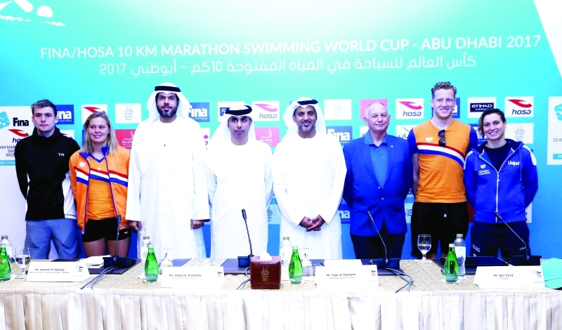 "■ طلال الهاشمي وعبدالله الوهيبي مع أبطال السباحة خلال إعلان تفاصيل الماراثون | البيان"