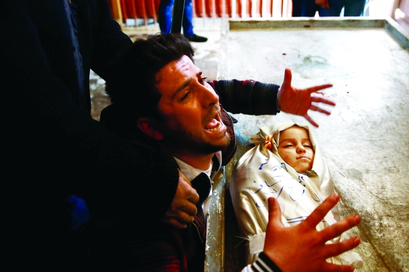 "أب يبكي طفله الذي قتل في جريمة جديدة للنظام السوري بقصف دوما | رويترز"