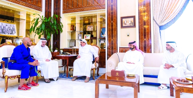 "■ حميد بن راشد النعيمي وعمار بن حميد يستمعان إلى البطل الحوسني بحضور أحمد بن حميد والجرمن"