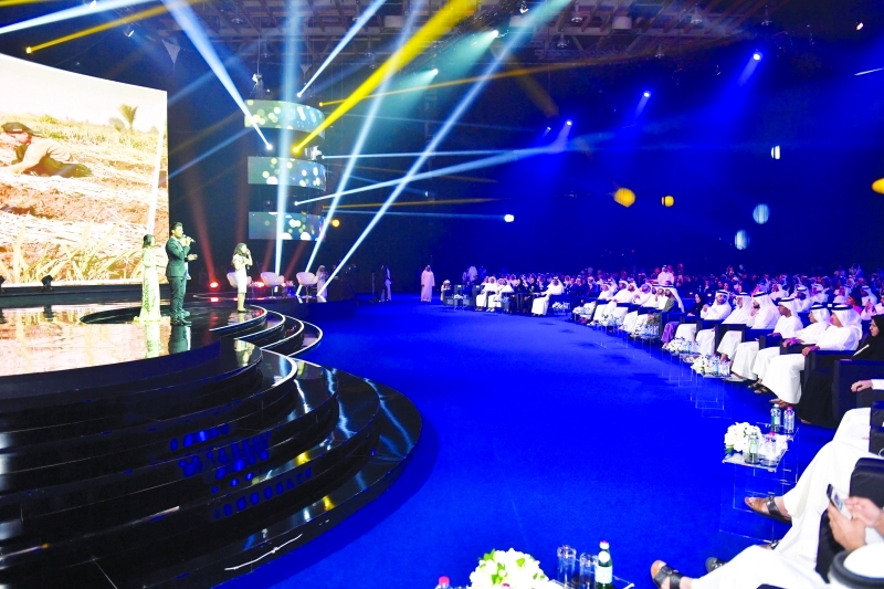 "محمد بن راشد متابعاً الحفل بحضور حمدان ومكتوم بن محمد وأمل القبيسي وأحمد بن سعيد وأحمد بن محمد ونهيان بن مبارك ومحمد القرقاوي والحضور"