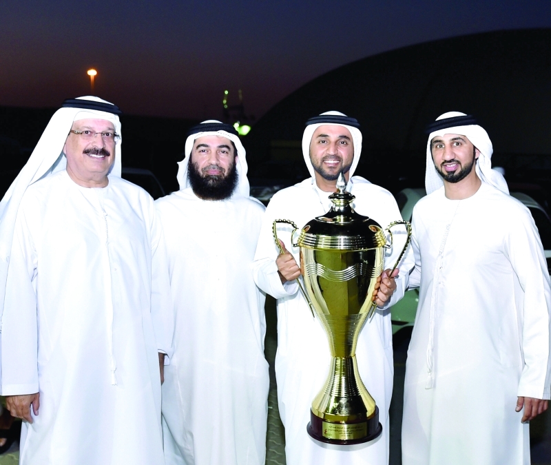 "■ خليفة سليمان يحمل كأس البطولة وإلى جانبه كبار الحضور  |   البيان"