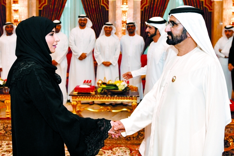 "محمد بن راشد مصافحاً الطالبات الأوائل بحضور حمدان بن محمد ومحمد القرقاوي وحسين الحمادي وأحمد الفلاسي"