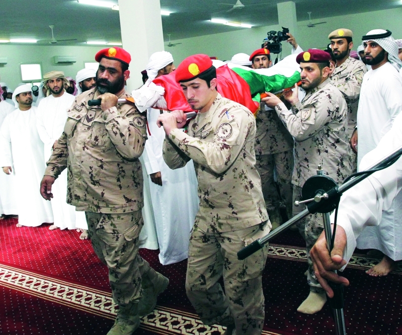 "■ رفاق السلاح يحملون جثمان الشهيد"