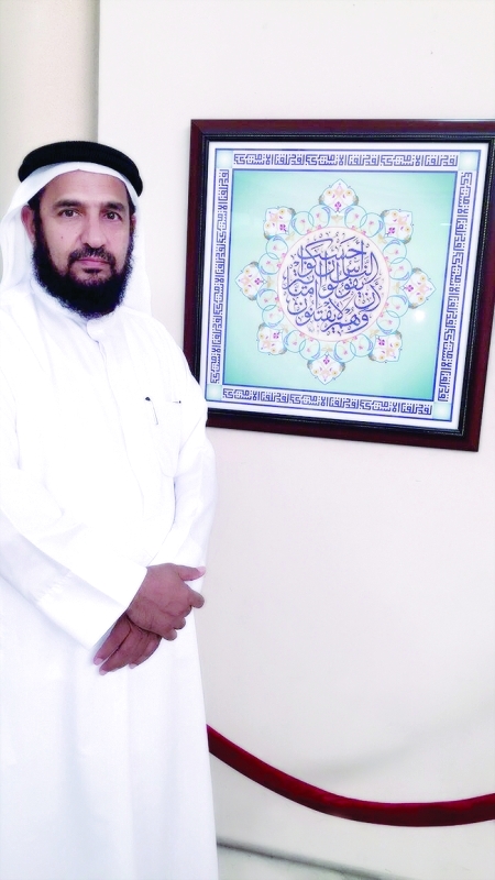"شهاب الكعبي أمام إحدى لوحاته في المعرض | البيان"