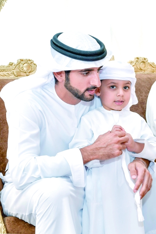 "حمدان بن محمد يحتضن أحد الأطفال خلال تقديم العزاء"