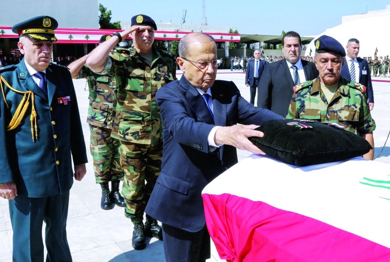 "عون يضع الأوسمة على نعوش العسكريين ـــ أ.ف.ب"