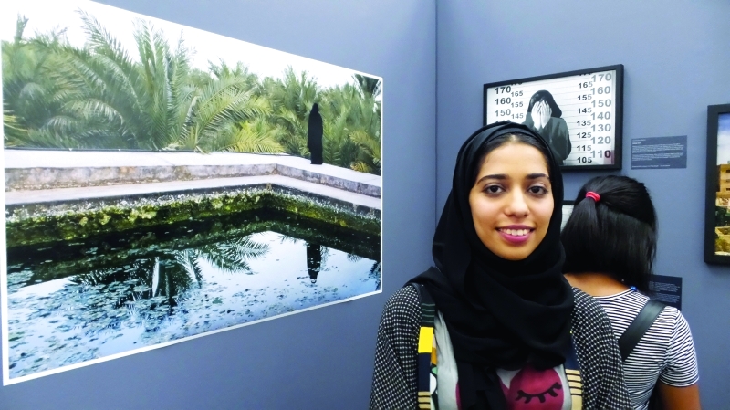"سارا سرّاء أمام صورة لها ترصد مفردات الطبيعة في رأس الخيمة | البيان"
