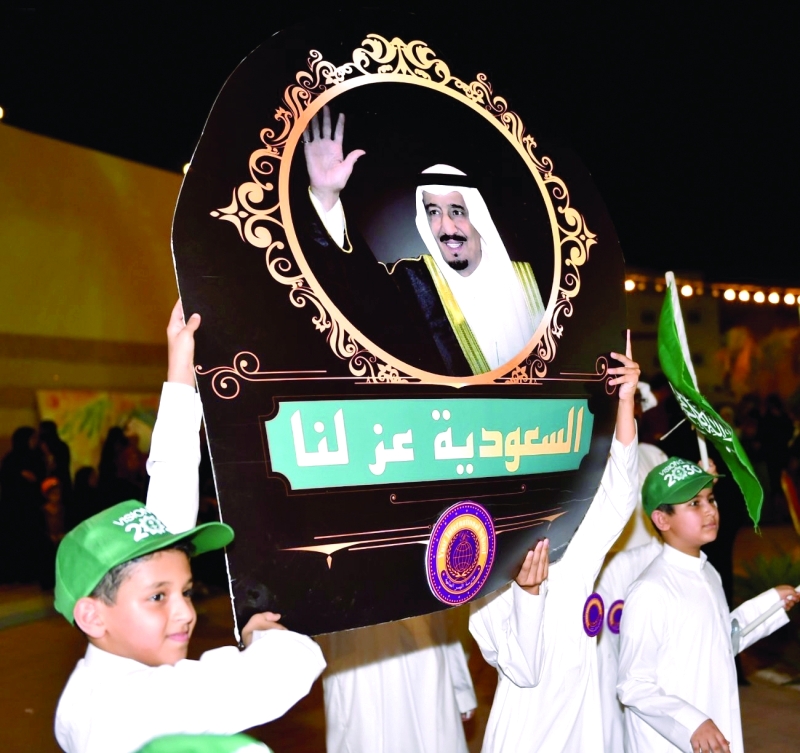 "أطفال سعوديون يرفعون صورة الملك سلمان في الاحتفالات بالعيد الوطني (واس)"
