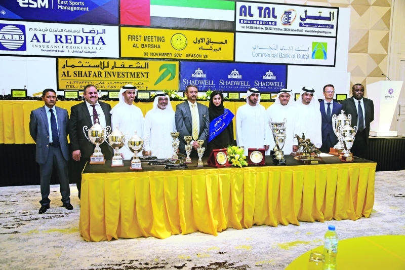 "Ⅶ شريف الحلواني يتوسط المشاركين في المؤتمر الصحافي مع جوائز السباق | تصوير - عبد الله المطروشي"