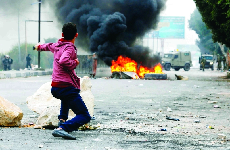 "فتى يواجه جنود الاحتلال خلال مواجهات نابلس | أ.ف.ب"