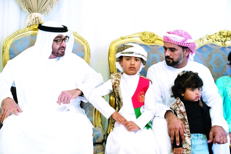 "محمد بن زايد متوسطاً أنجال الشهيد وأسرته خلال تقديم واجب العزاء"