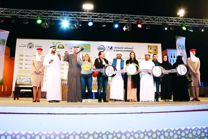 "الفائزون بالسيارات الأربع مع مديرة المهرجان وممثلي الشركات الراعية | تصوير: مرهف العساف"