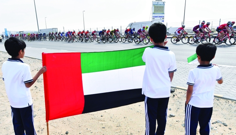 "طفلان يحملان العلم الإماراتي ويتابعان السباق | أ ف ب"