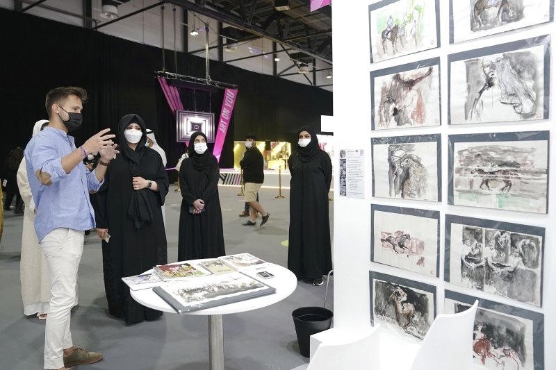 "لطيفة بنت محمد مستمعة إلى شرح عن المعروضات"