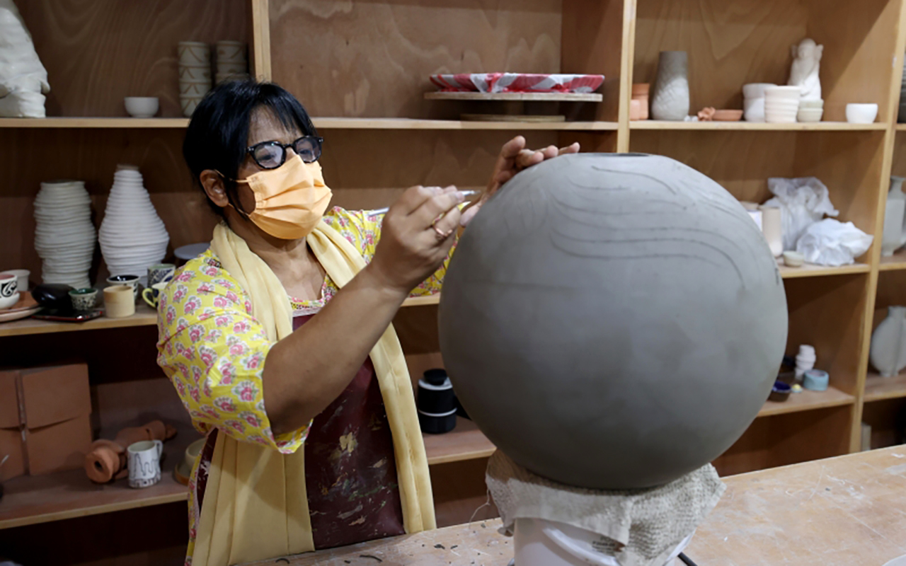 "شمسة تمارس تشكيل الطين في محترف «بيت الطين» | تصوير: سالم خميس"