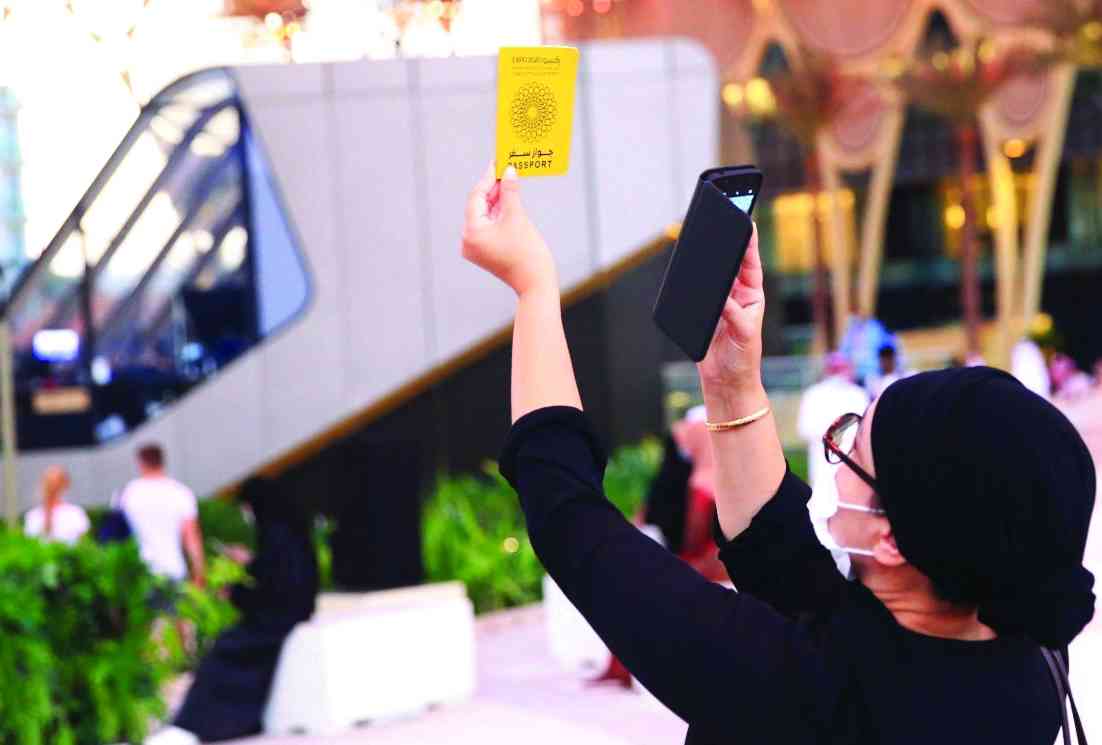 "» زائرة تلتقط صورة لجواز سفر إكسبو"