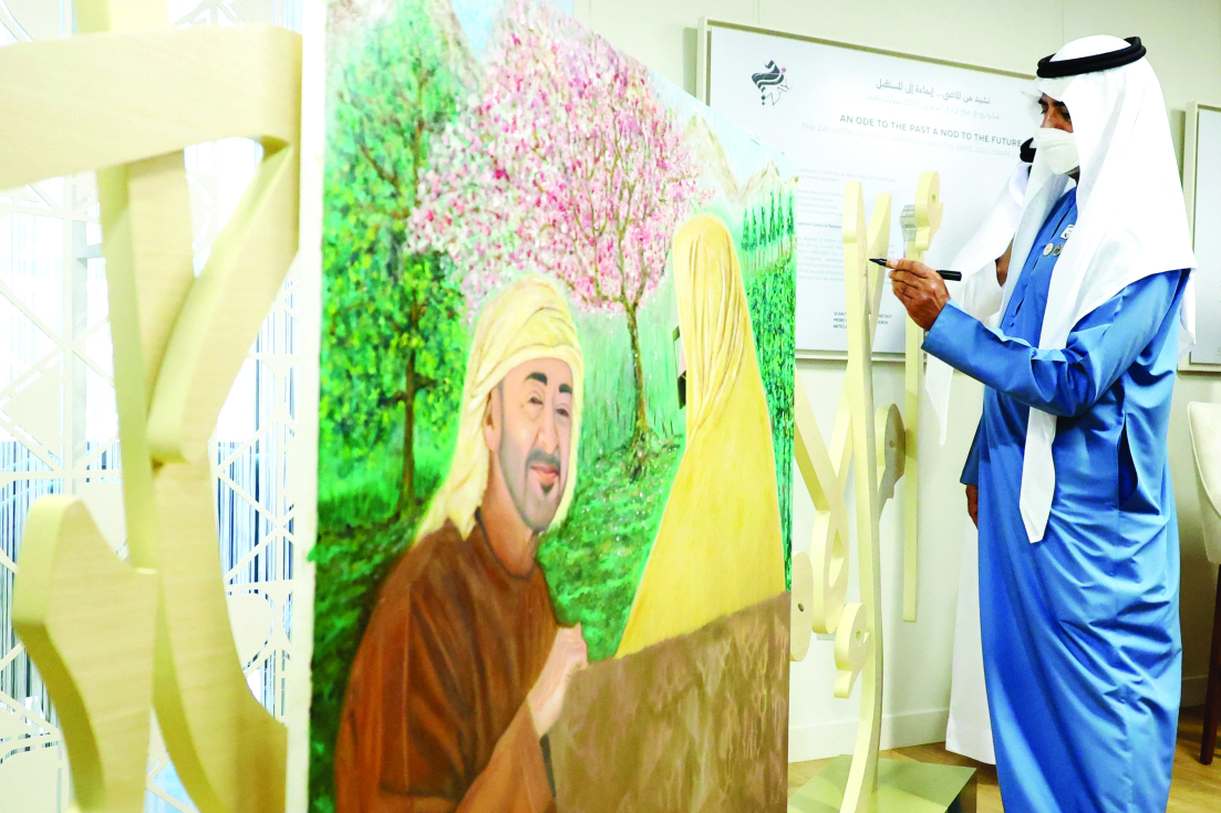 "» نهيان بن مبارك يدوّن كلمة تذكارية على لوحة رمزية تمثل «أم الإمارات» ومحمد بن زايد | تصوير: زافير ويلسون"