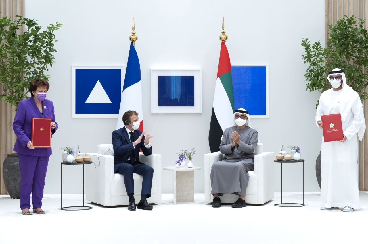 "محمد بن زايد وماكرون خلال تبادل التعديل على اتفاقية «اللوفر » بين محمد المبارك وروزلين باشلو"