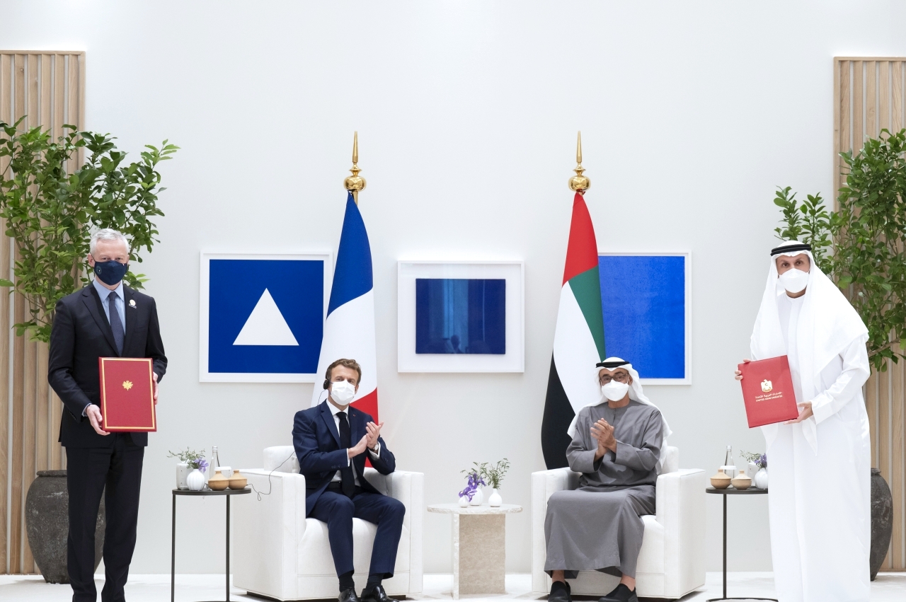 "محمد بن زايد وماكرون خلال تبادل مذكرة بين خلدون المبارك و برونو لومير"