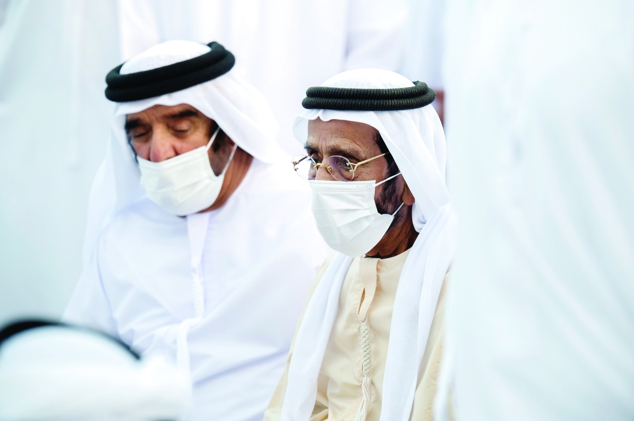 "طحنون وسيف بن محمد خلال تشييع الجثمان"