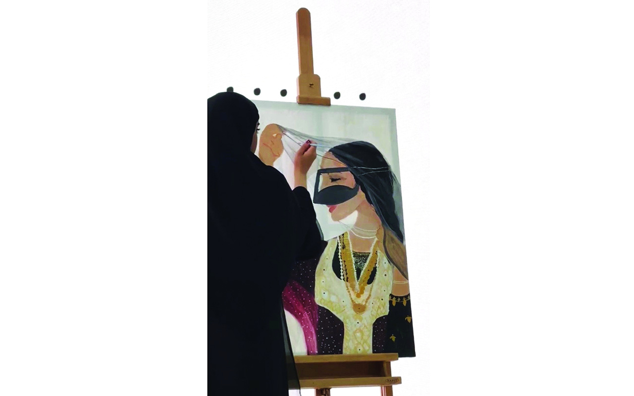 "حصة المعلا مع إحدى لوحاتها"