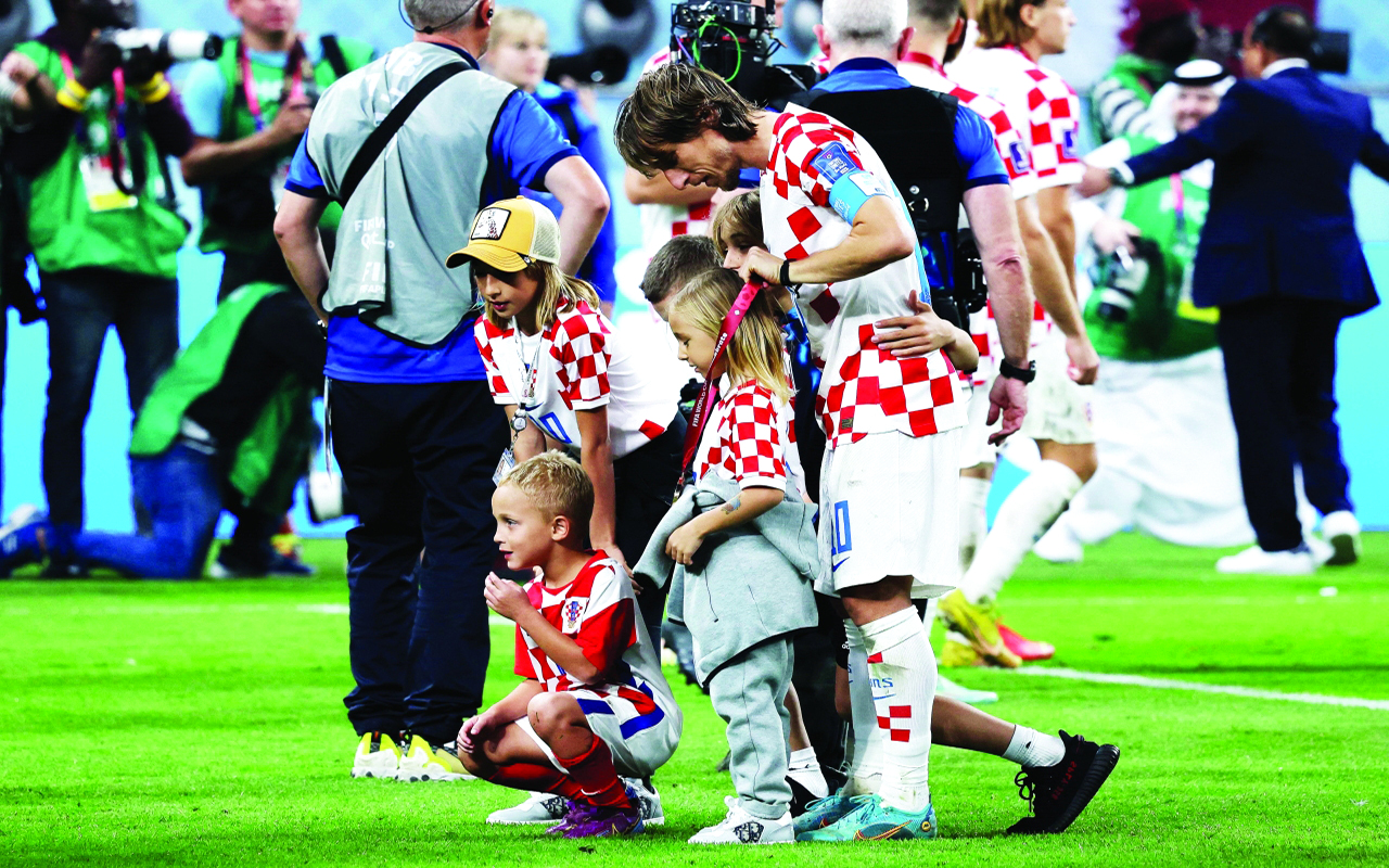 "Croatia's midfielder #10 Luka Modric and his children celebrate with his medal after winning the Qatar 2022 World Cup third place play-off football match between Croatia and Morocco at Khalifa International Stadium in Doha on December 17, 2022. (Photo by KARIM JAAFAR / AFP)"