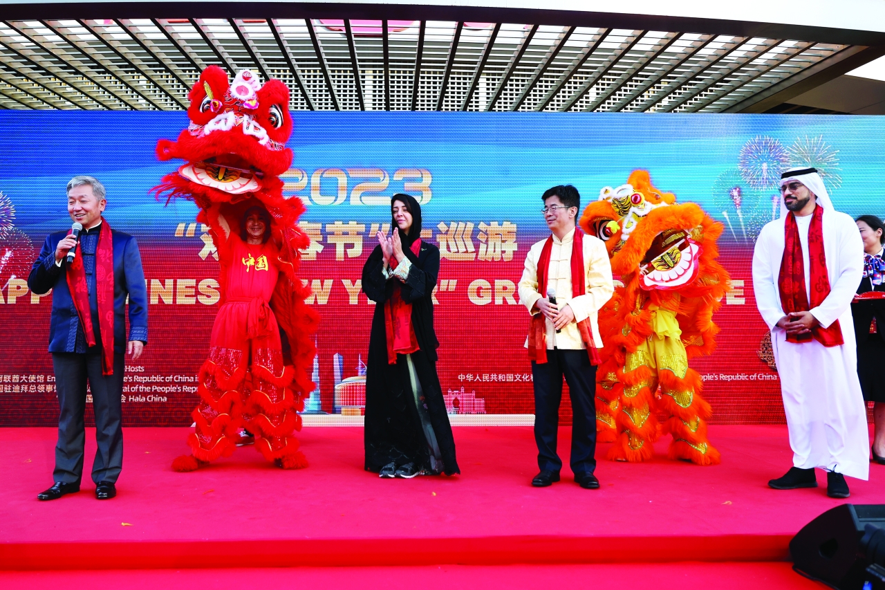 "ريم الهاشمي ومسؤولان صينيان خلال الاحتفالية | تصوير: سالم خميس"