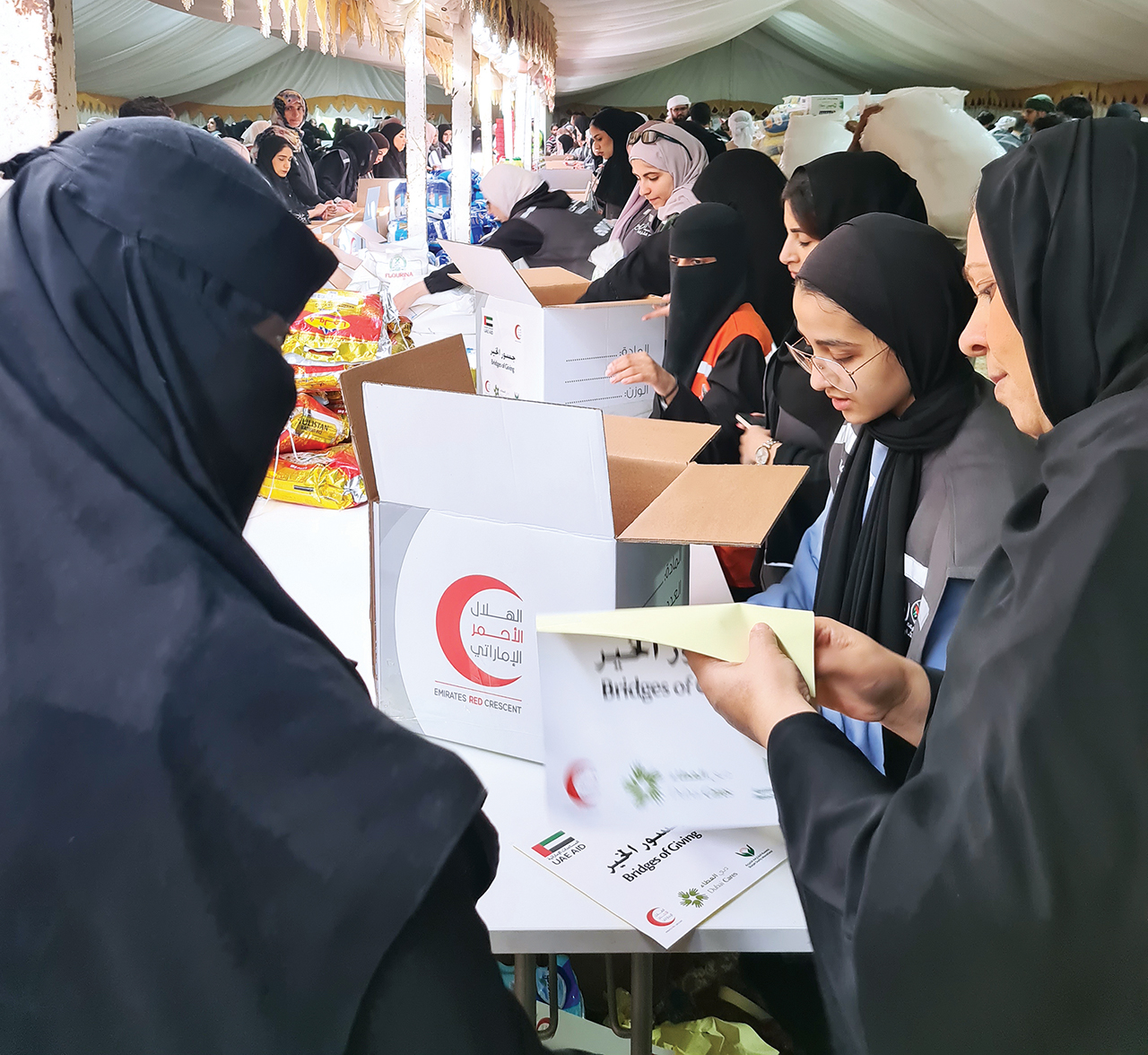 "جانب من المتطوعين في الشارقة لجمع التبرعات العينية وترتيبها"