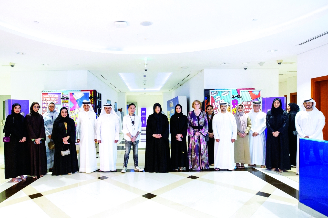 "لطيفة بنت محمد تتوسط المنظمين والمشاركين في المعرض بحضور هالة بدري وإيزابيل بالهول وأحمد بن ركاض العامري وأندرو ياب | من المصدر"