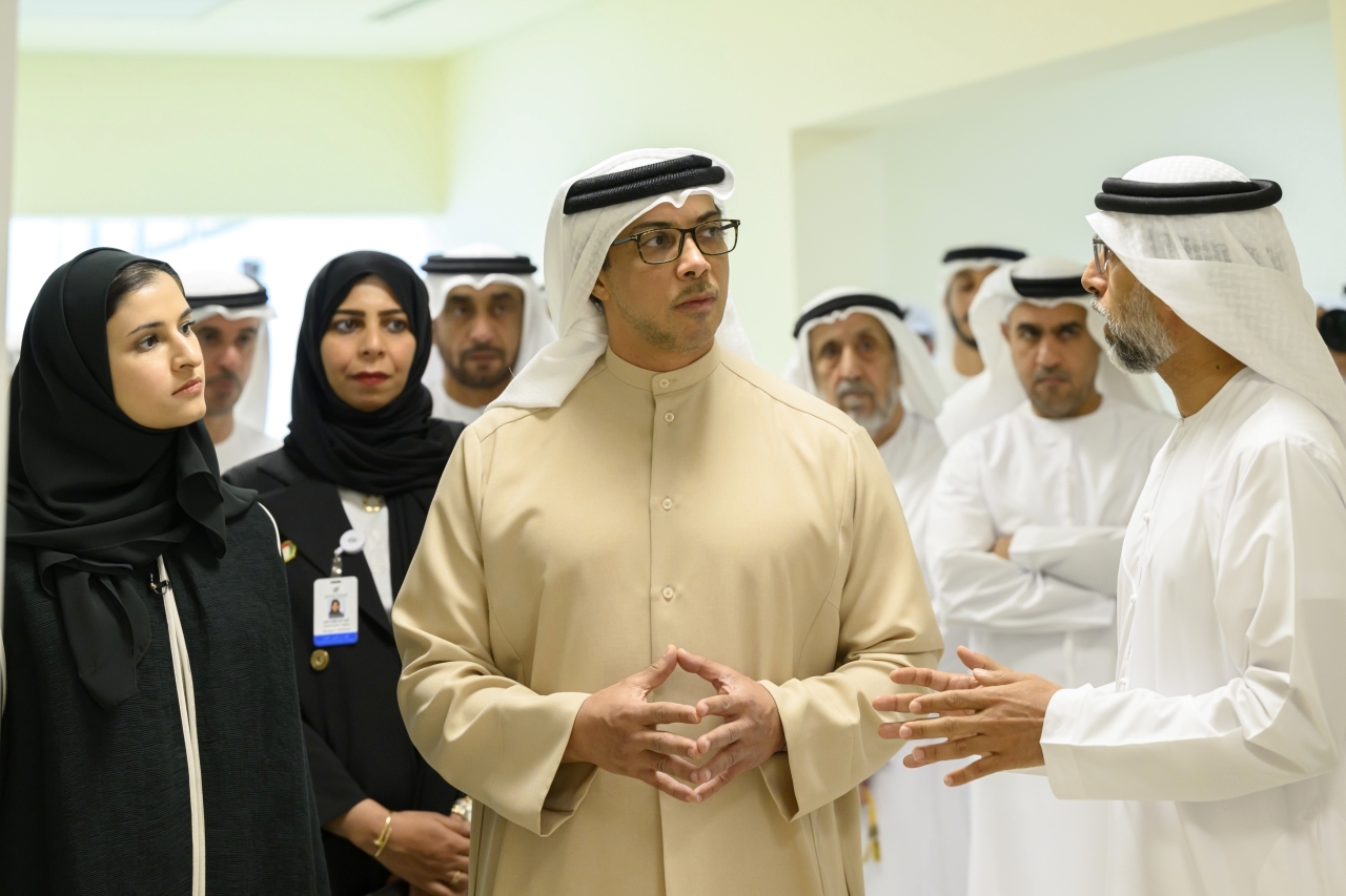 "منصور بن زايد يستمع لشرح من سهيل المزروعي بحضور سارة الأميري وعدد من المسؤولين"