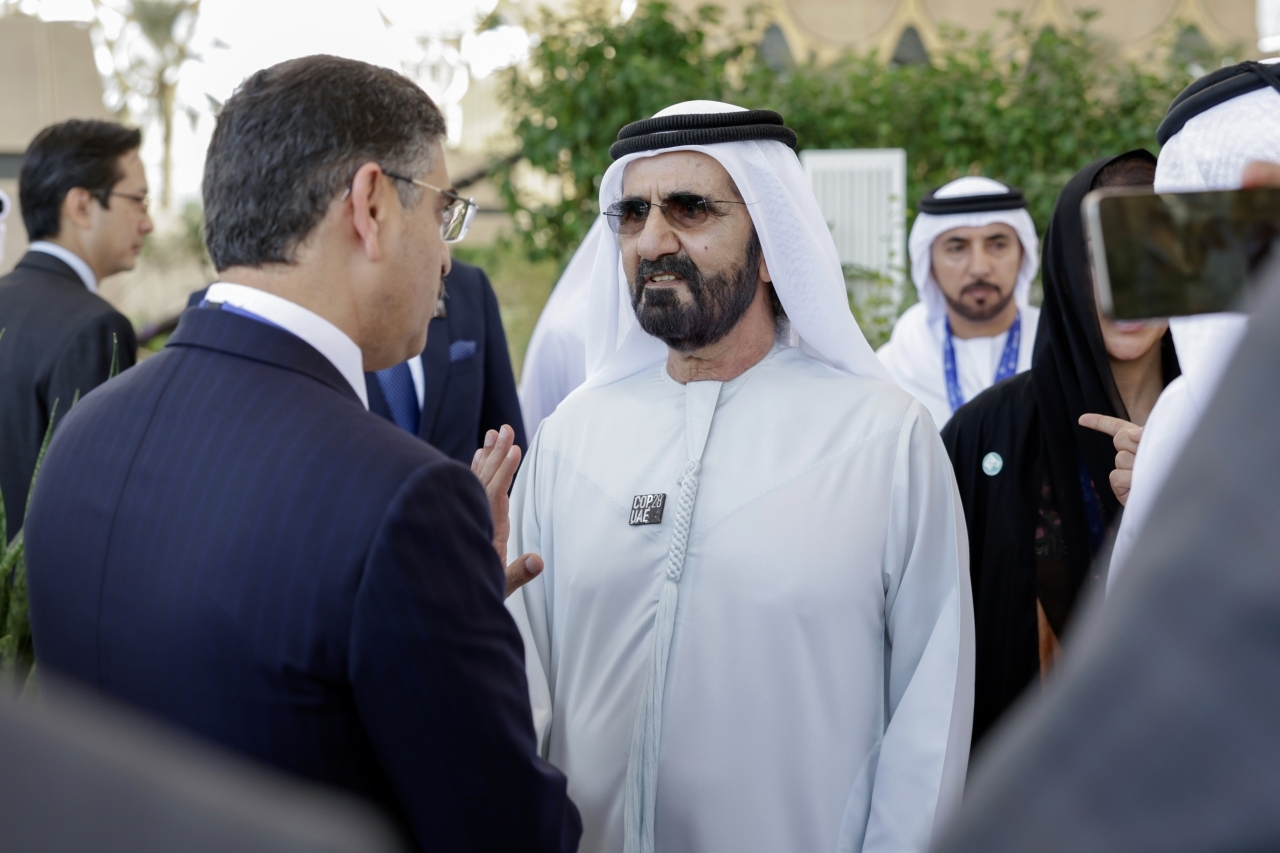 "محمد بن راشد في حديث مع أحد الضيوف بحضور سلطان السبوسي"