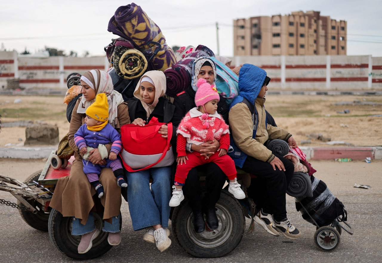 "أفراد عائلة فلسطينية نازحة يتكدسون فوق عربة نقل | رويترز"