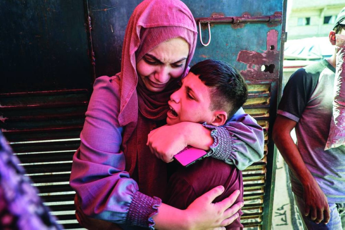 فلسطينيون يبكون أحباءهم الذين قضوا في غارات إسرائيلية على مخيم البريج وسط قطاع غزة