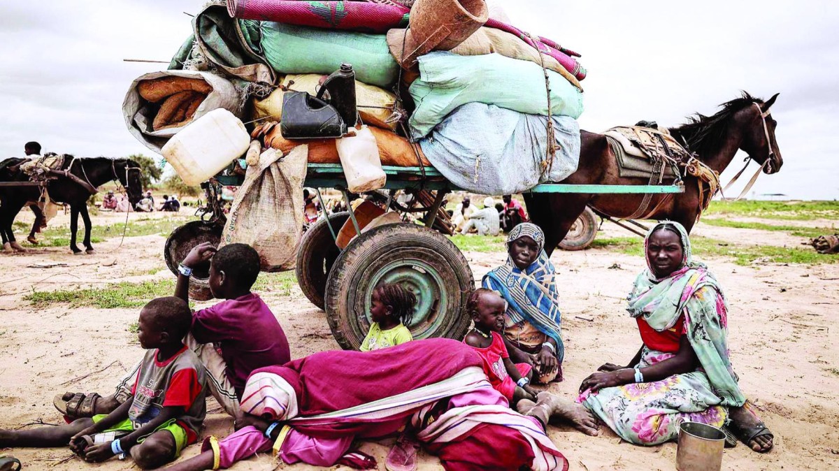 عائلة سودانية فرت من الصراع تجلس بجانب أمتعتها في أدري بتشاد