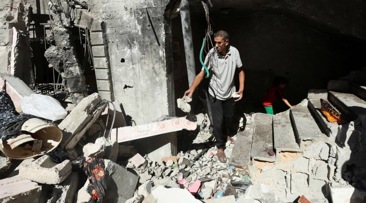 فلسطيني يتفقد آثار غارة إسرائيلية على منزل في وسط قطاع غزة