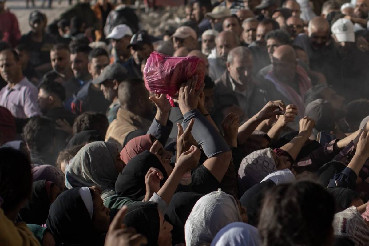 عشرات الأشخاص يصطفون خارج مخبز في مدينة خان يونس للحصول على حصتهم من الخبز