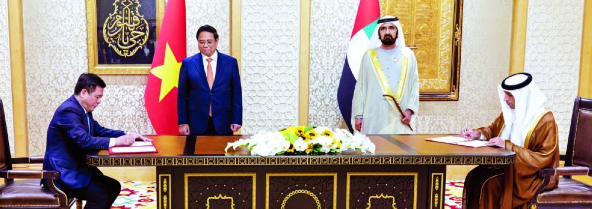محمد بن راشد وفام تشينه خلال توقيع ثاني الزيودي ونجوين هونغ دين على الاتفاقية