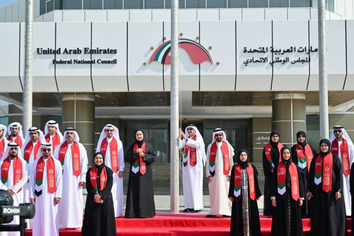 صقر غباش والأمناء العامون والموظفون خلال رفع العلم في مقر المجلس الوطني