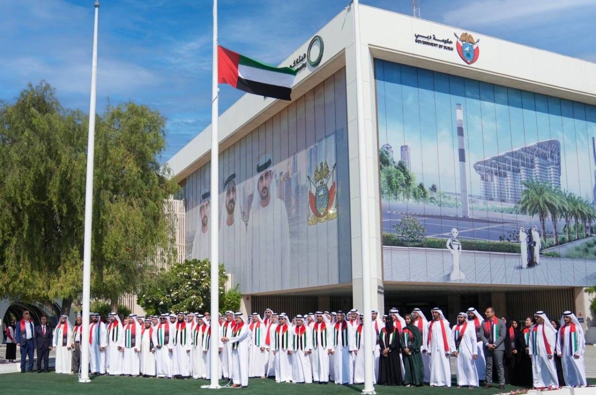 سعيد الطاير ومسؤولو هيئة الكهرباء خلال رفع العلم