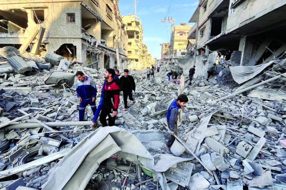 فلسطينيون وسط الدمار الذي خلفته غارة إسرائيلية في بيت لاهيا شمال قطاع غزة |
