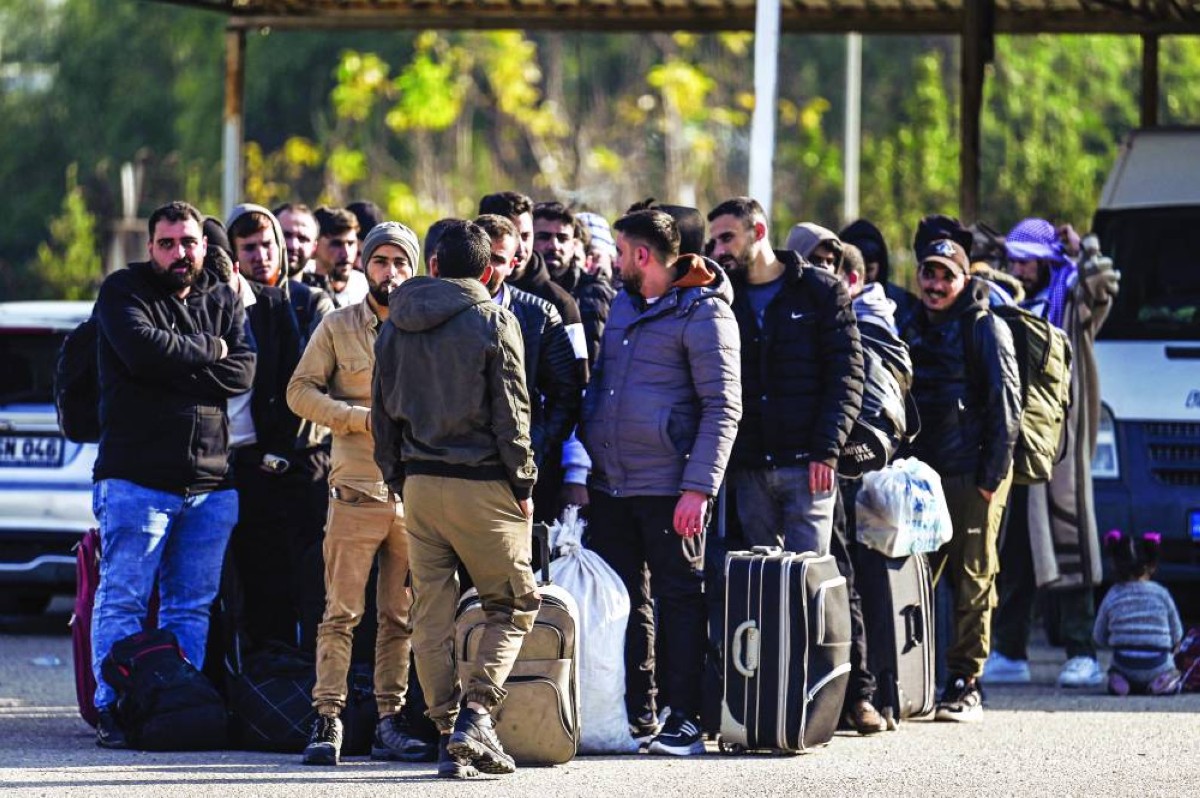 لاجئون سوريون عند بوابة سيلفجوزو التركية قبل الدخول إلى سوريا