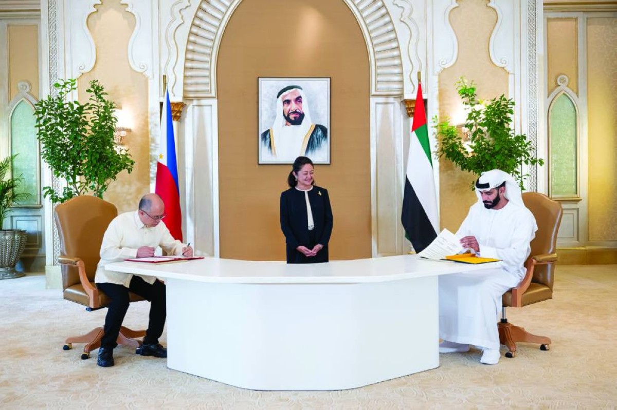 سالم القاسمي ومسؤول اللجنة الفلبينية خلال توقيع مذكرة التفاهم
