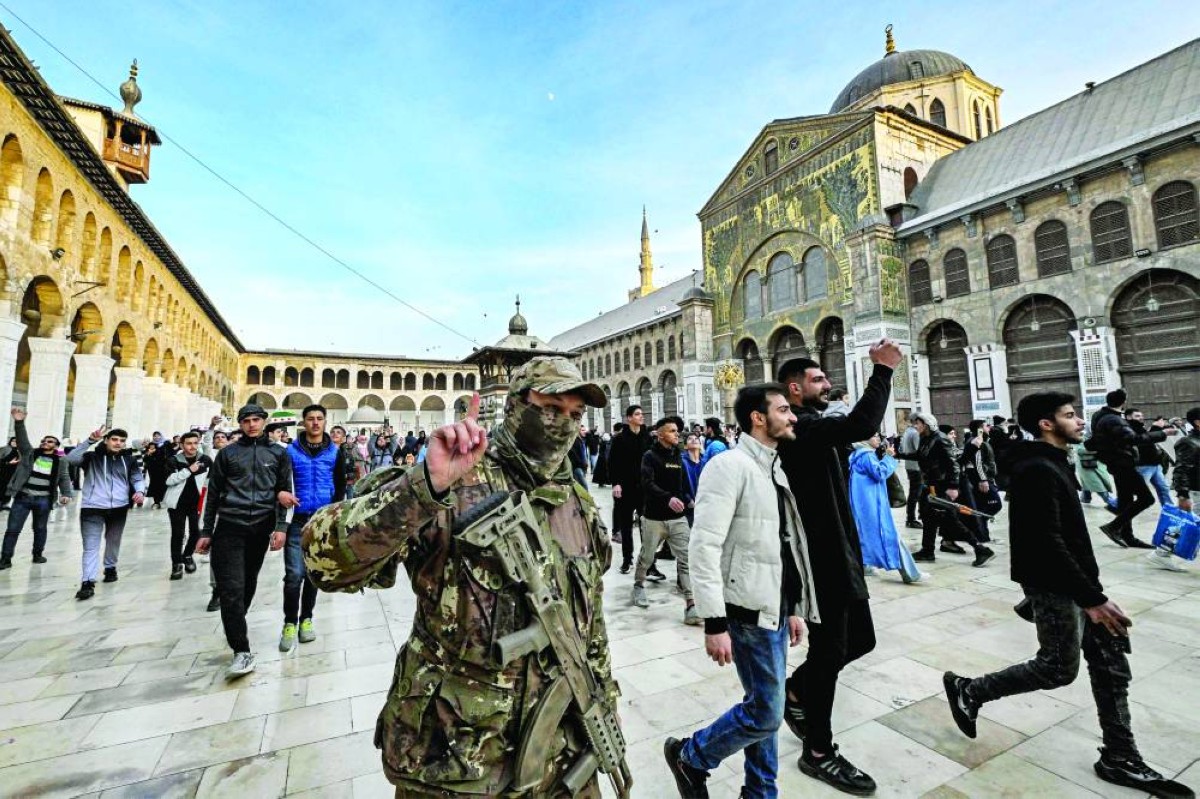 مسلح ومواطنون سوريون في باحة الجامع الأموي بدمشق