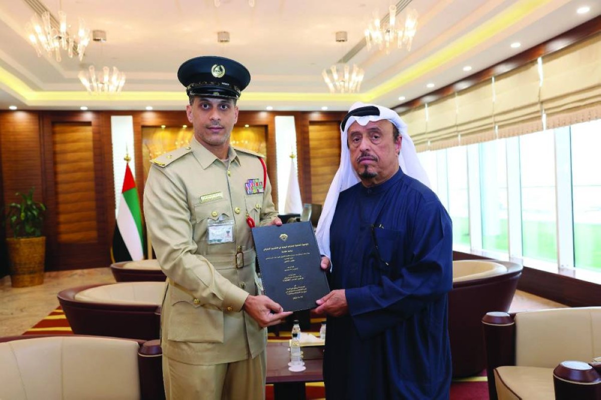 ضاحي خلفان متسلّماً نسخة من رسالة الماجستير من زايد العولقي