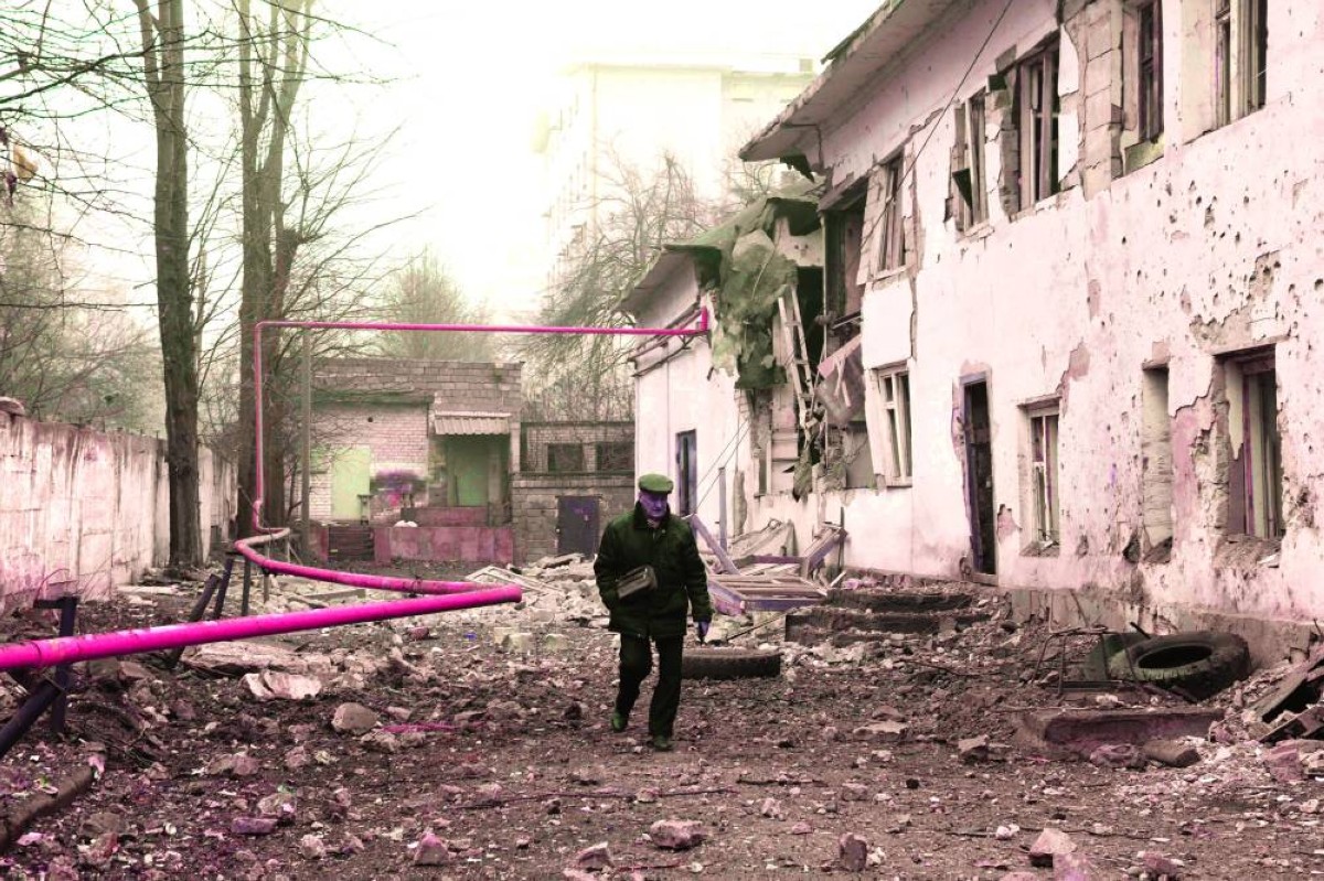 رجل يسير في موقع أصابه القصف في دونيتسك
