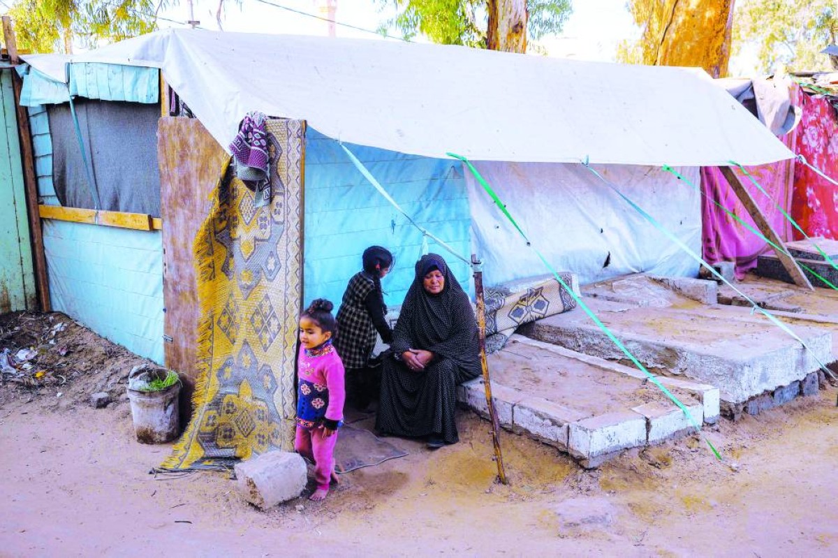 أسرة تيسير عبيد تقيم بخيمة حفرت لها بالأرض في دير البلح درءاً للبرد